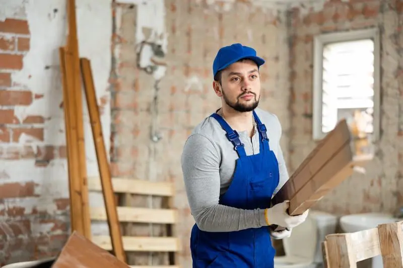 Construction worker carrying wooden planks