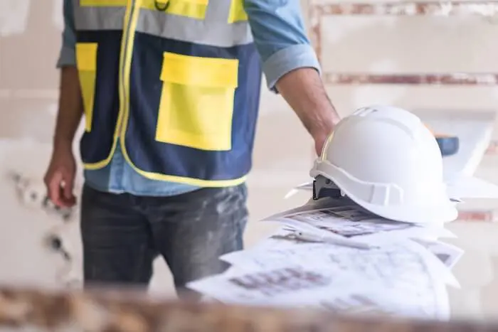 Construction worker holding blueprints