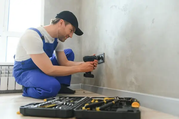 Electrician fixing power outlet tools